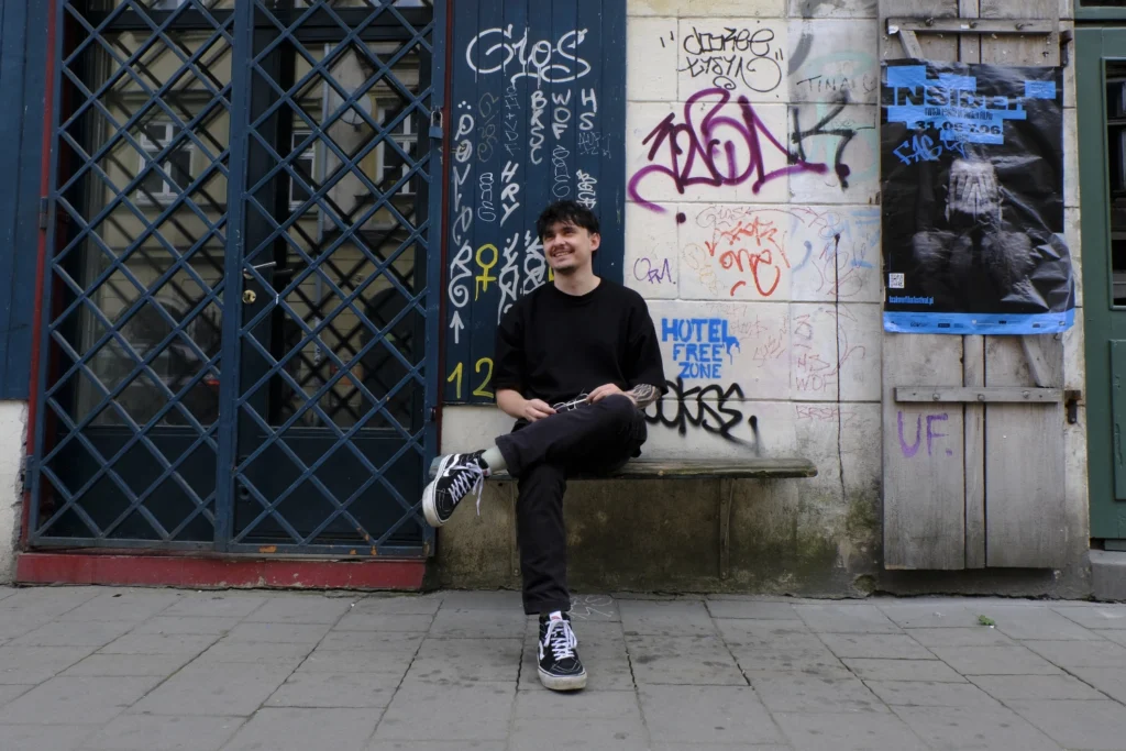 Davor Kujundzic auf einer Sitzbank vor einer Mauer mit Grafitti